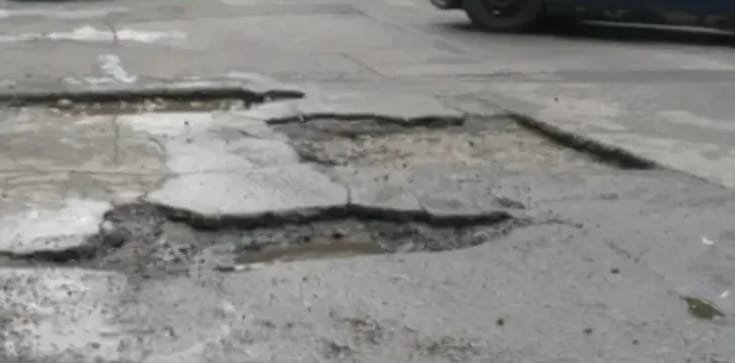 Cluj-Napoca: apă care curge continuu pe o stradă distruge asfaltul, iar șoferii riscă să-și strice mașinile