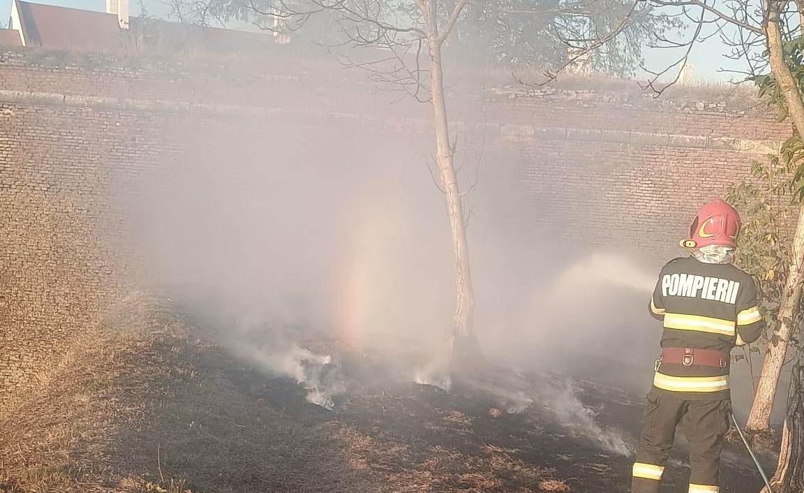 FOTO: Incendiu de vegetație uscată în șanțurile Cetății la Alba Iulia. Acționează pompierii din municipiu