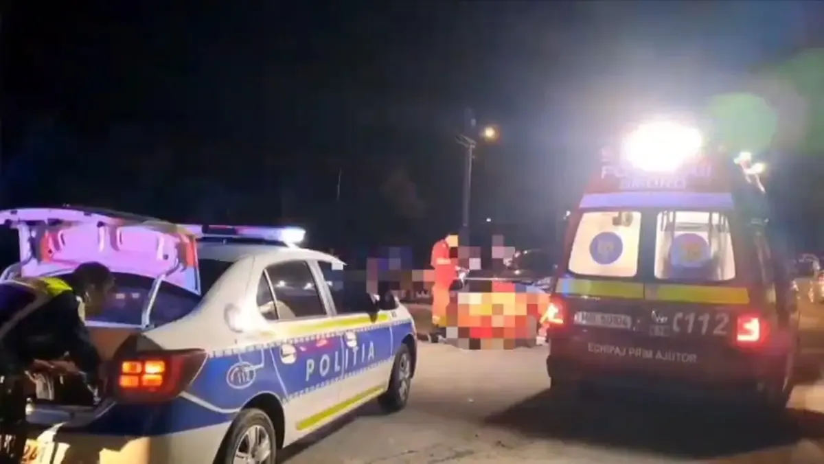 Noaptea, la fața locului unui accident rutier: o mașină de poliție, o ambulanță SMURD cu girofarul aprins și un echipaj de intervenție care se ocupă de o persoa