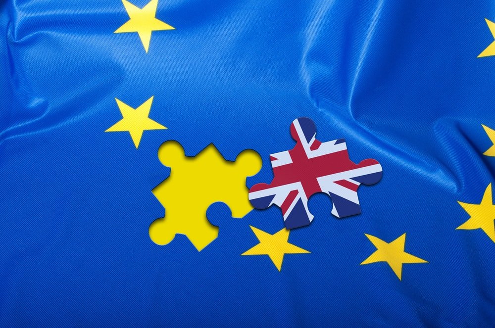 Steagul UE cu o piesă de puzzle cu Union Jack care se potrivește într-un gol din steag, imagine simbolică a revenirii Regatului Unit în UE.